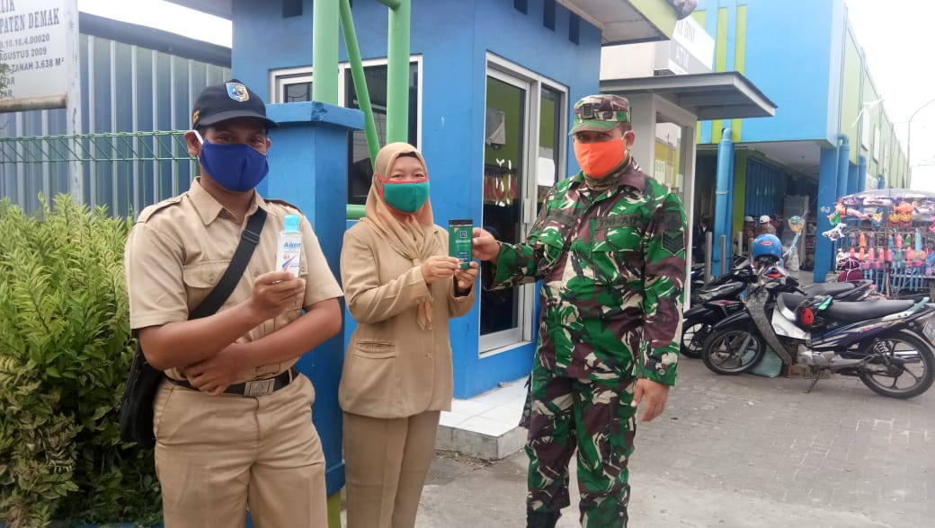 Petugas Penjaga Pintu Keluar Masuk Pasar Karanganyar Dibantu Oleh Bapak Dari Koramil