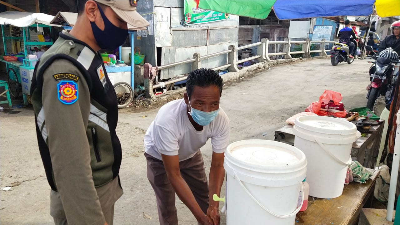 Pengunjung Pasar Wonopolo Melakukan Cuci Tangan Sebelum Memasuki Area Pasar